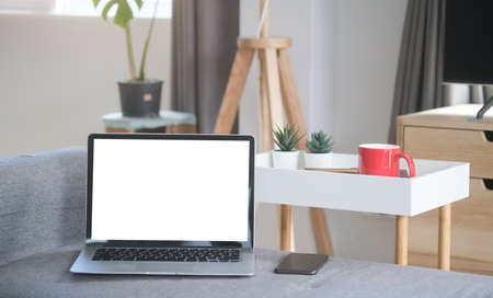 Businessman working with laptop on white table in minimal office.