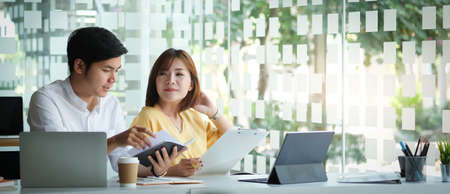 Two businesspeople preparing their project with digital device in modern office.