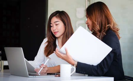 Concept business woman working and people happy businesswoman or creative female office worker with computers writing to notebook with documents and laptop.の写真素材