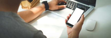 Mock up smartphone of hand holding black mobile phone with blank white screen.の写真素材