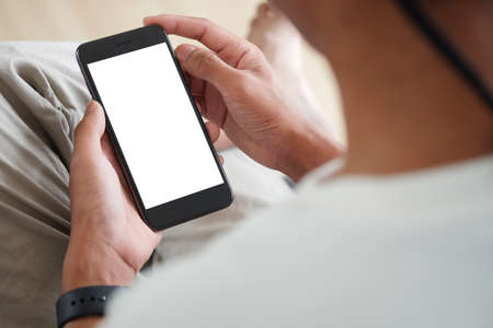 Mock up smartphone of hand holding black mobile phone with blank white screen.