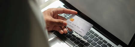 Close up view of man holding credit card. Online shopping or online payment.