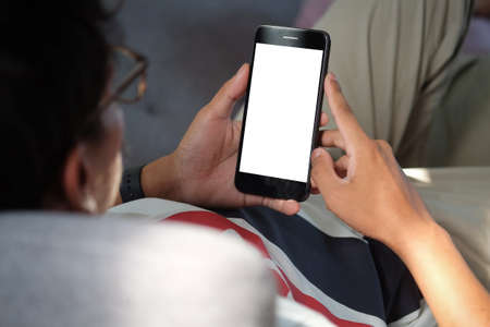 Mock up smartphone of hand holding black mobile phone with blank white screen.の写真素材