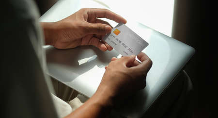 Close up view of man holding credit card. Online shopping or online payment.の写真素材
