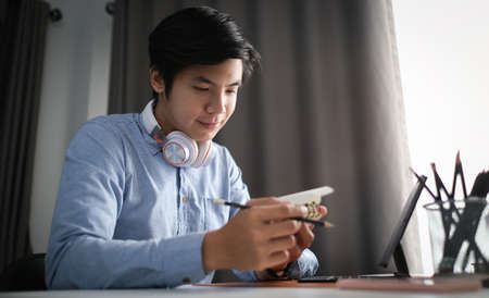 Side view of calm businessman concentrate reading book while sitting in home office.