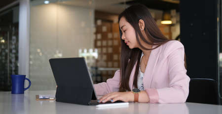 A young female administrative assistant making notes of working planning organizing information in...