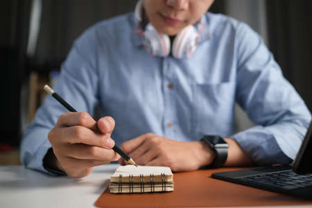Side view of calm businessman concentrate reading book while sitting in home office.