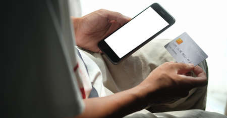 Close up view of man holding credit card. Online shopping or online payment.