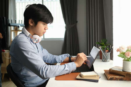 Business woman reading information on paperwork and using laptop working on desk.の写真素材