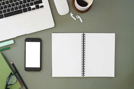 Top view of a graphic designer or photographer workspace with digital tablet, coffee cup, and notebook on white table. Blank screen for advertise text.の写真素材