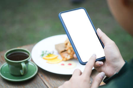 Mock up smartphone of hand holding black mobile phone with blank white screen.の写真素材