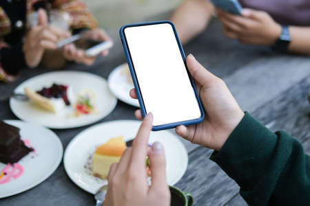 Mock up smartphone of hand holding black mobile phone with blank white screen.の写真素材