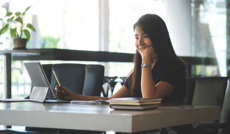 A young female administrative assistant making notes of working planning organizing information in her office.の写真素材