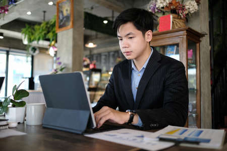 Cropped shot of businessman working with computer tablet at home office.の写真素材