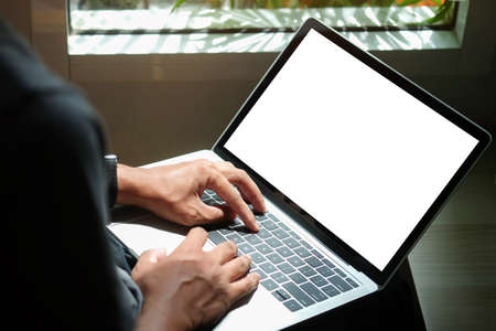 Back view of young businessman working on new project with computer tablet at his home office.
