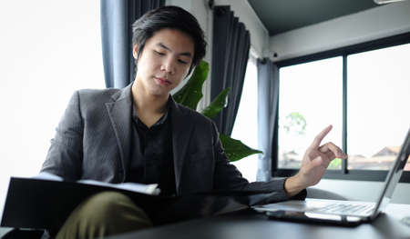 Businessman reading financial reports at office.