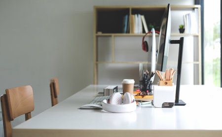 Creative designer workplace near window with computer, headphone and office supplies.の写真素材