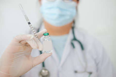 Doctor holding a syringe with vaccine in hands. Medicine and drug concept.の写真素材
