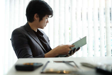 Peaceful businessman reading report in modern office.の写真素材