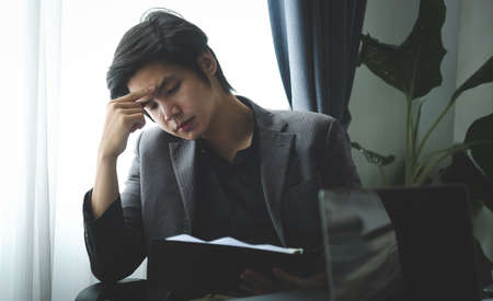 Serious businessman reading financial document in office.