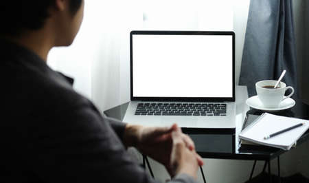Businessman reading business information on laptop computer at office room.