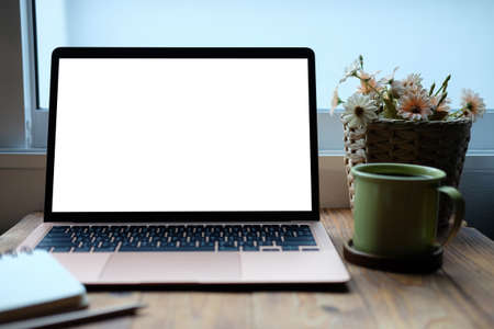 Close up view computer laptop with blank screen, coffee cup, notebook on wooden desk.の写真素材
