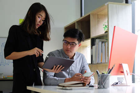 Two business people discussing business data with digital tablet together.の写真素材
