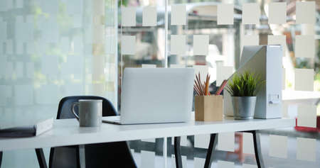 Modern office with laptop computer and supplies on white desk.の写真素材