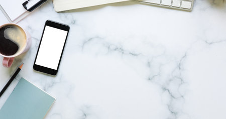 Mock up smart phone, coffee cup and notebook on marble table.の写真素材
