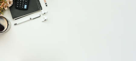 Above view simple workspace with calculator, coffee cup and notebook on white table. Top view.の写真素材