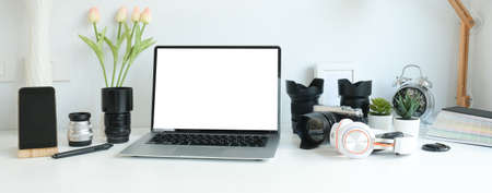 Photographer workplace with computer laptop, smart phone and camera on white table.の写真素材