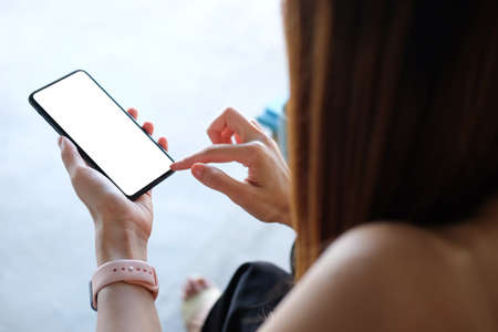 Young woman using smart phone while sitting in her workplace.の写真素材