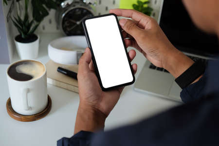 Businessman holding smart phone with blank screen.