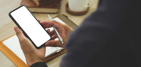 Man holding mock up smart phone. Blank screen for your text message or information content