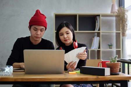 Two young creative designer discussing for their new project together in office.