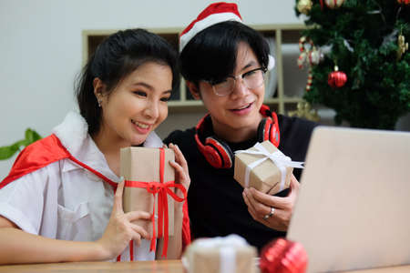 Two Asia people relax smile laugh greeting remotely talk to friend video call Merry Xmas eve festive...