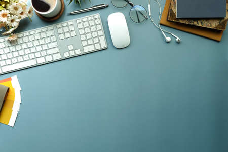 Above view cup of coffee, glasses, pencil holder and keyboard on creative designer workspace.