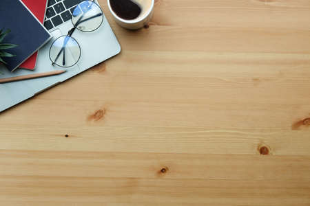 Top view cup of coffee, earphone, keyboard and glasses on wooden background.の写真素材
