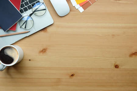 Creative designer workspace with laptop computer, coffee cup and glasses on wooden table.の写真素材