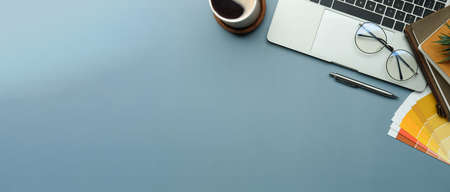 Above view wireless keyboard, coffee cup and notebook on blue backgroundの写真素材