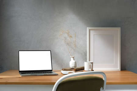 Modern workplace, computer laptop and supplies on wood table with loft wall.