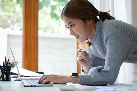 Beautiful asian woman holding credit card and using computer laptop. Concept of online shopping,...
