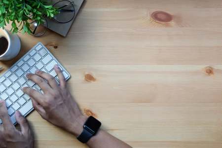 Overhead view man freelancer hands typing on wireless keyboard.の写真素材