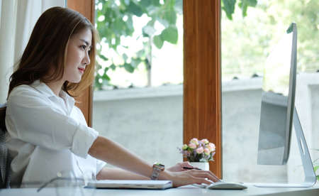 Side view beautiful asian businesswoman working with computer.