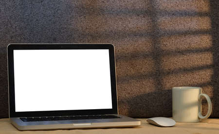 Computer laptop, wireless mouse and coffee cup on white table. Blank screen for advertisement text.