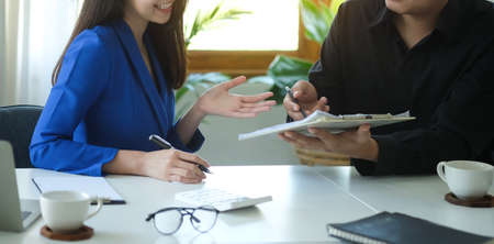 Smiling businesswoman discussing new strategy with her business partner.の写真素材