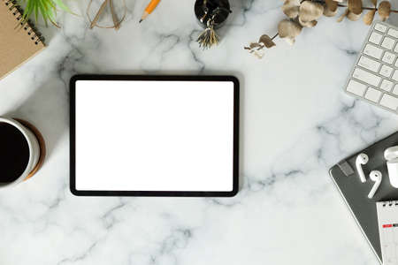Feminine workplace with digital tablet, wireless earphone and coffee cup on marble background.の写真素材