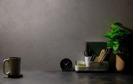 Coffee cup, supplies and potted plant on black table. Copy space.の写真素材