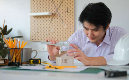 Smiling Architect engineer man working on architectural plan project in office.の写真素材