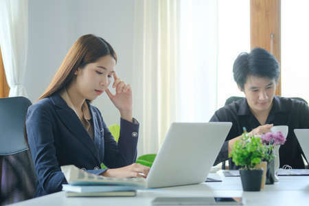 Two young business people sitting in modern office and discussing project strategy together.の写真素材